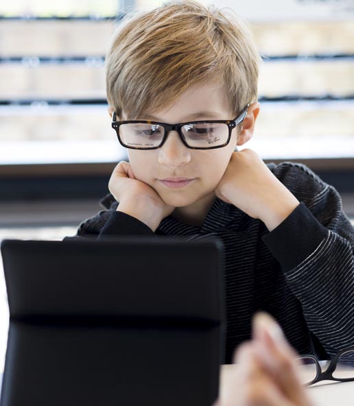 Child looks at the mirror after Pediatric Eye Care consultation in Omaha