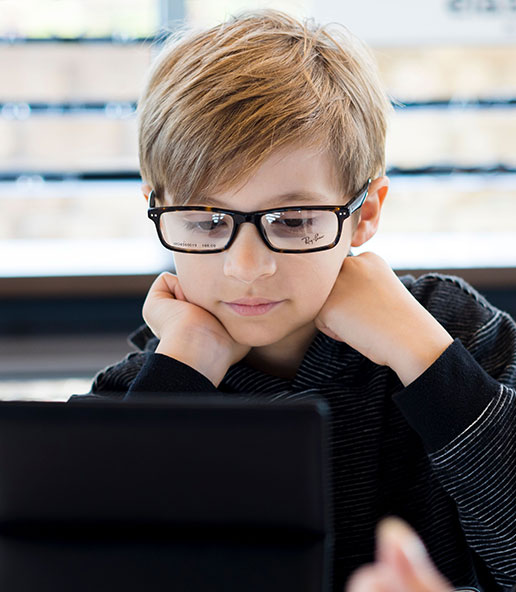 young child trying on designer ray-ban glasses at Vision Specialists