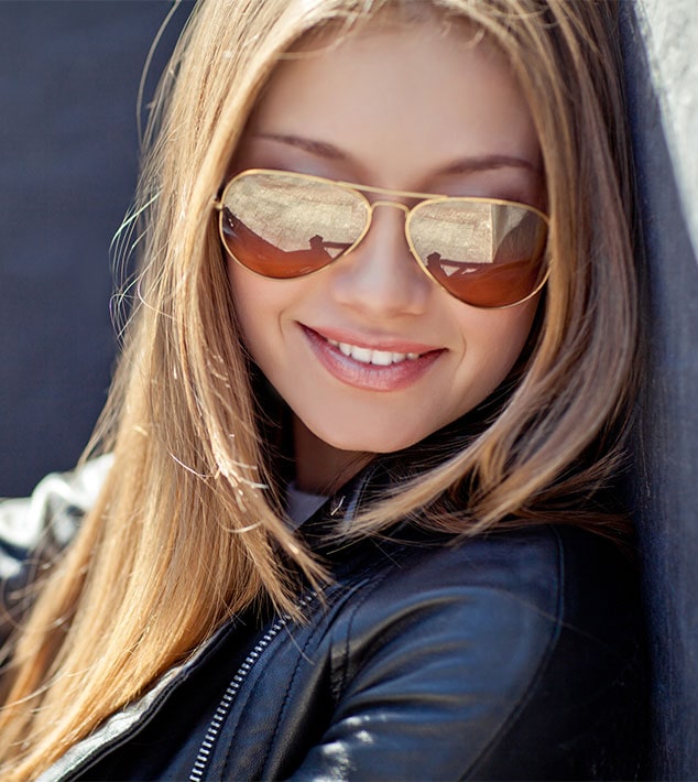 Female wearing designer prescription sunglasses from Vision Specialists