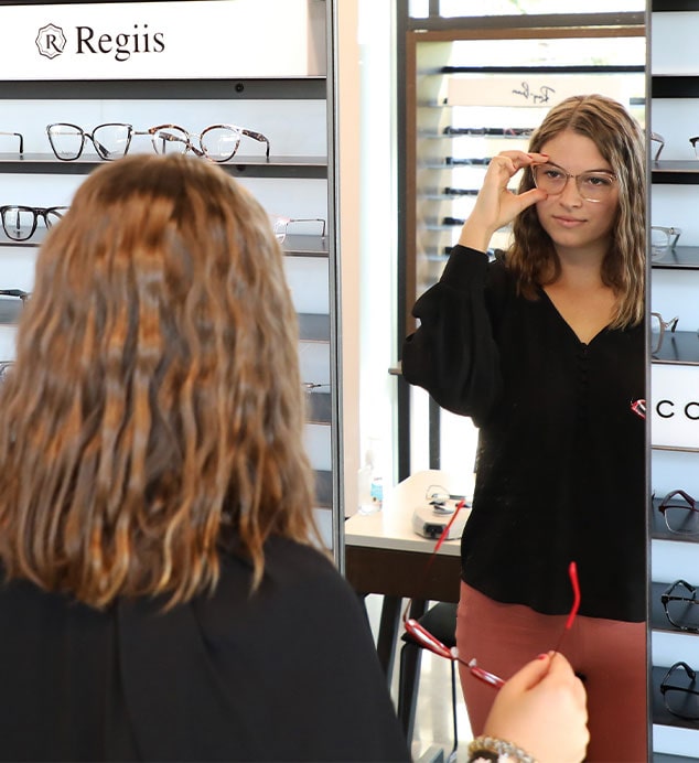 Woman trying on designer eyeglasses at Vision Specialists of Omaha