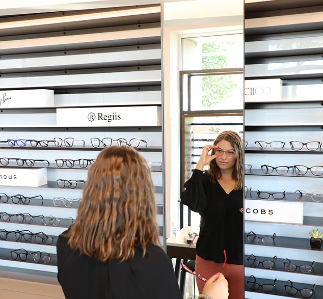 Woman trying on Eyeglasses at Vision Specialists